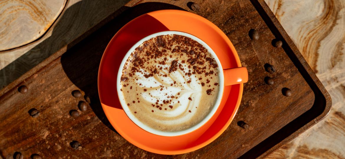 cup of perfectly made coffee in orange mug