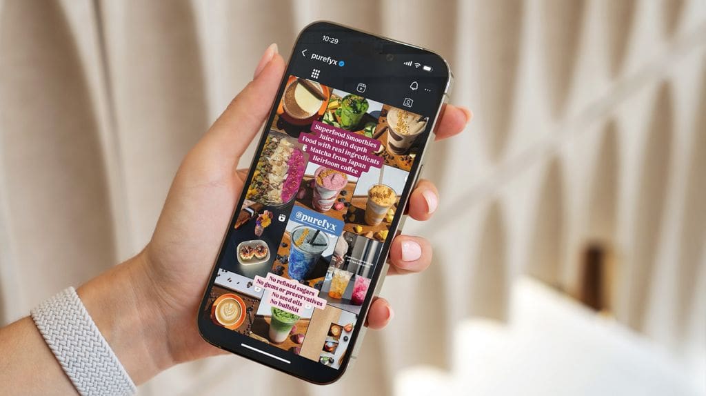 girl holding phone displaying Instagram grid of PureFyx account