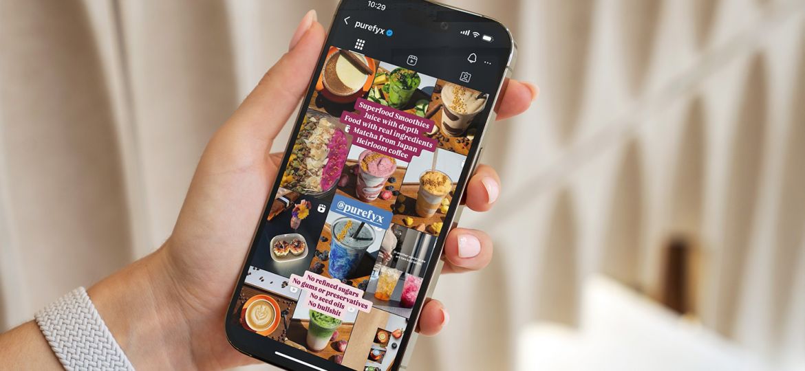 girl holding phone displaying Instagram grid of PureFyx account